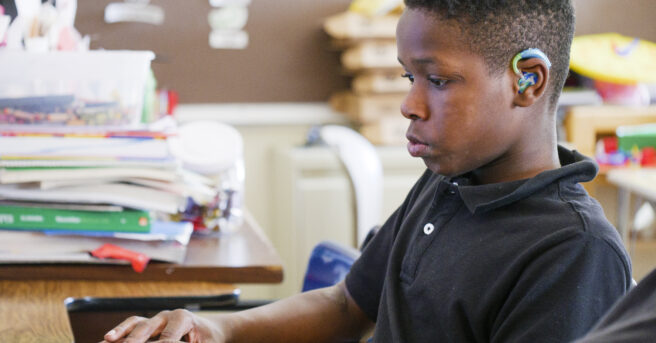 Student that is deafblind working on a computer.