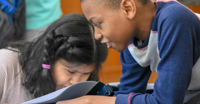 Two students working at school desks.
