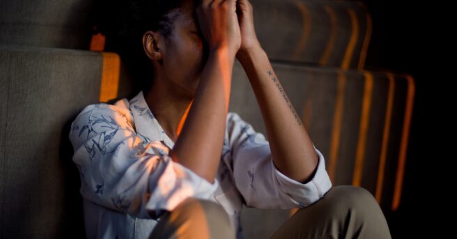 Young person with their head in their hands